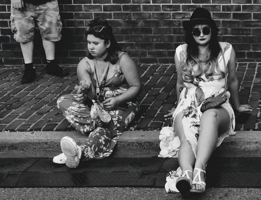 Two Girls Sitting on Sidewalk